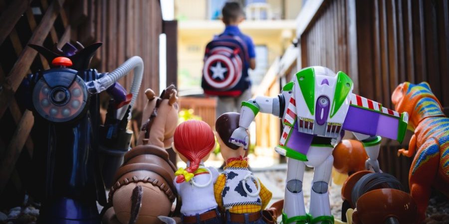 Boy standing with his back to a row of Toy Story toys