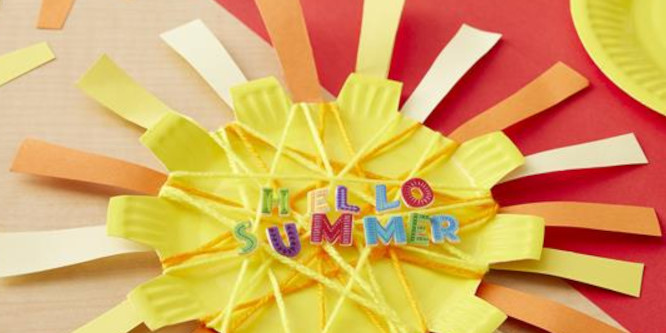 children's craft yellow sunburst made out of a yellow paper plate with orange and white construction paper extending from it as sunbeams, yarn holding it together, multicolored felt letters reading hello summer in the center of the sun