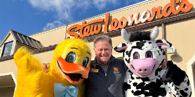 Stew Leonard in front of store with animal characters, a duck and a cow