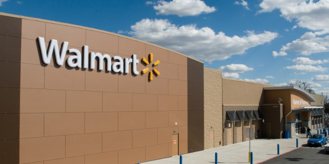 Image of a Walmart supercenter with a Walmart logo on the top of the brick building on the left